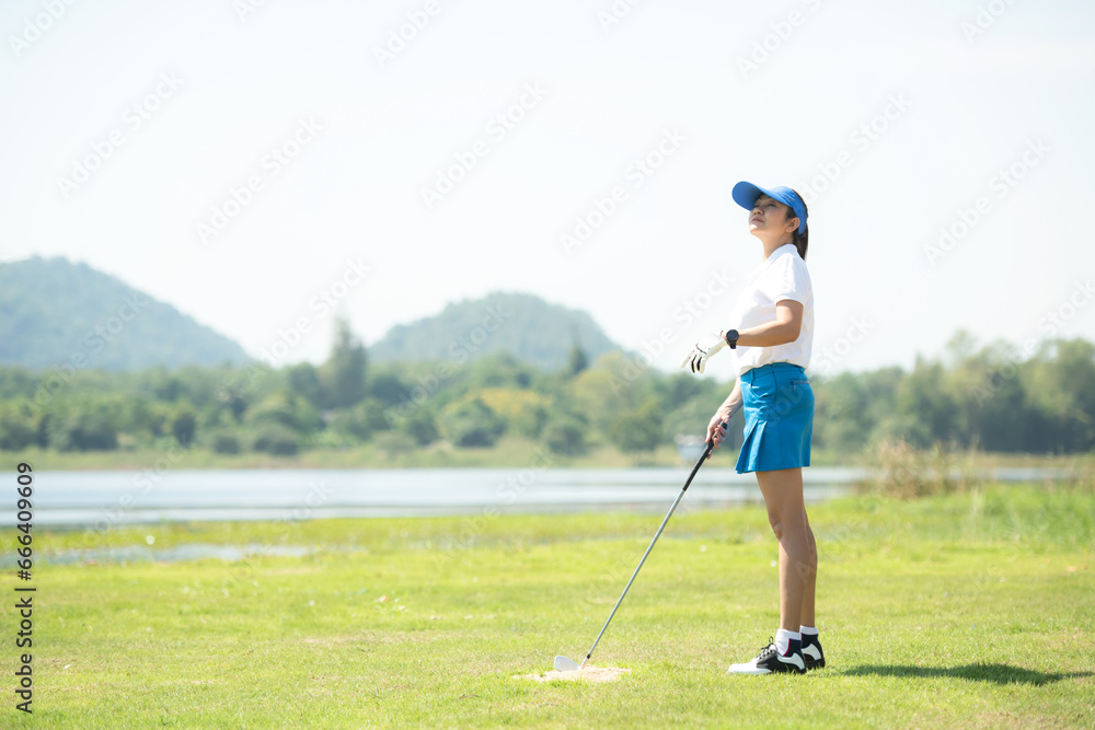 Golfer women sport course golf ball fairway. People lifestyle woman playing game golf approach tee of on the green grass mountain background. Asian female player game shot in summer Golfer women sport course golf ball fairway. People lifestyle woman playing game golf approach tee of on the green grass mountain background. Asian female player game shot in summer