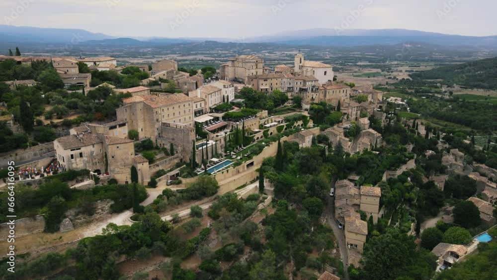 Aerial establishing shot of Gordes Village on hill with old buildings in France Aerial establishing shot of Gordes Village on hill with old buildings in France