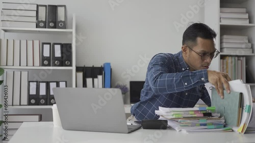 Stressed Asian businessman working with financial documents and stressed about work Tired employees are overloaded in the office.