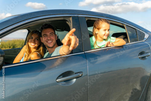 The family is sitting in the car, stepfather is showing his stepdaughter and his wife their vacation destination © DusanJelicic