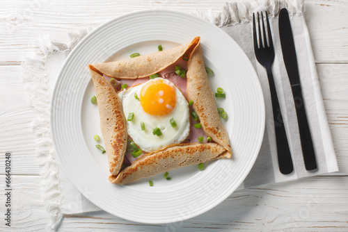 Tableau sur toile Galette complete Breton buckwheat pancake with egg cheese and ham closeup on the plate on the table