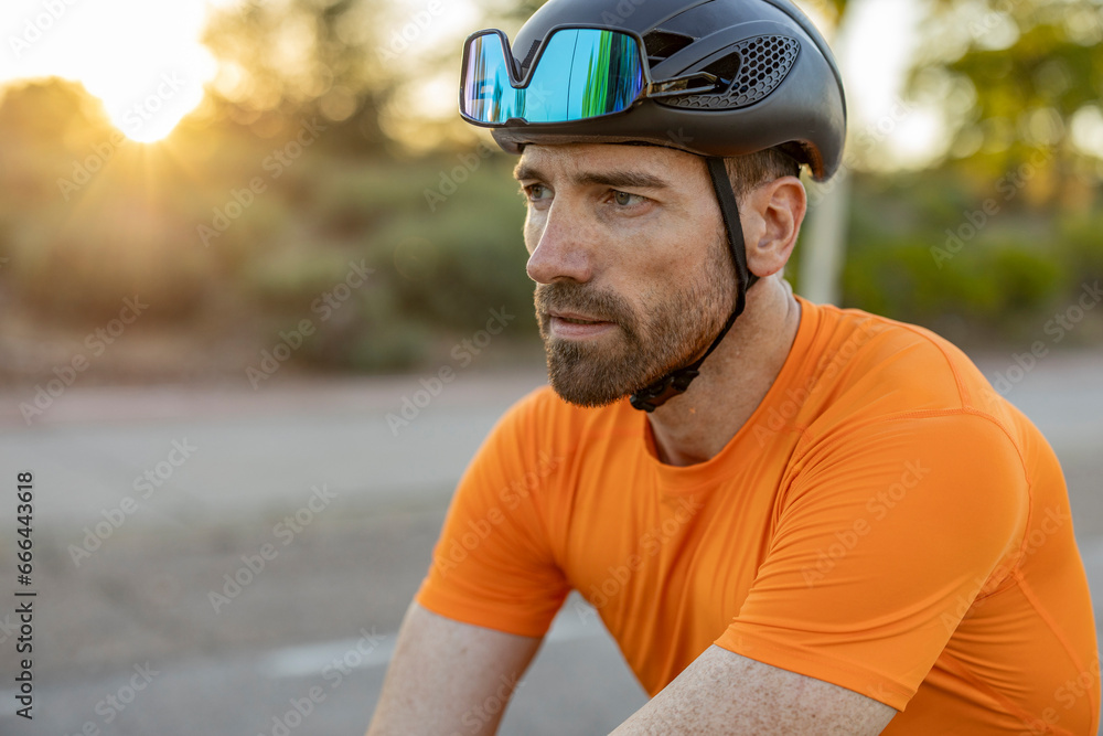 Contemplative man with sports helmet and sunglasses at sunset Contemplative man with sports helmet and sunglasses at sunset