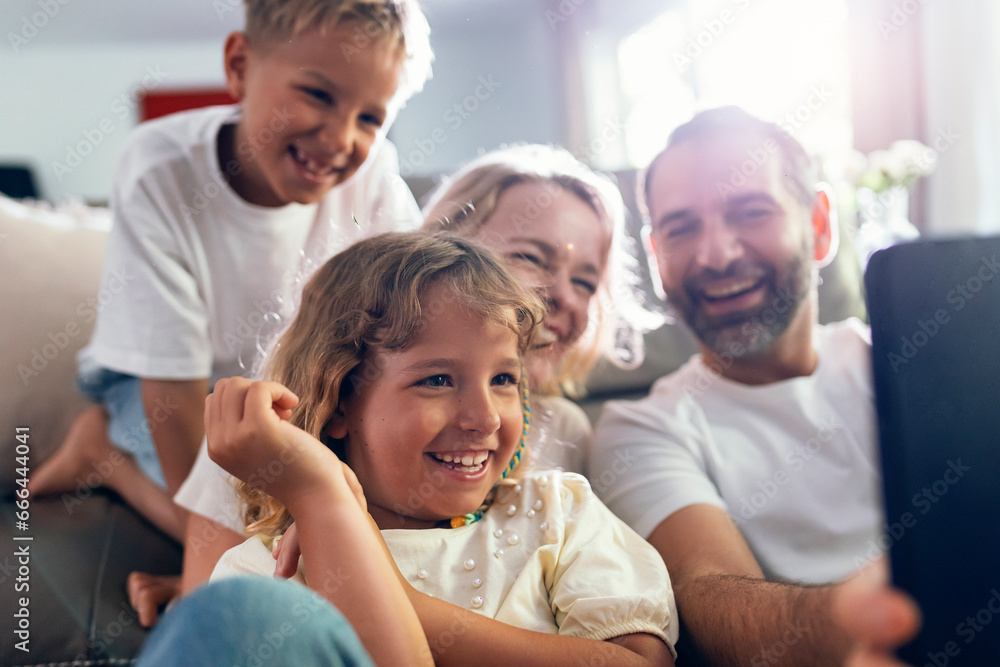 Smiling man taking selfie with family on mobile phone at home Smiling man taking selfie with family on mobile phone at home
