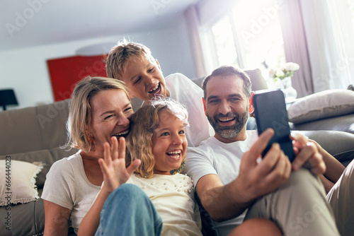 Cheerful family taking selfie on mobile phone at home photo