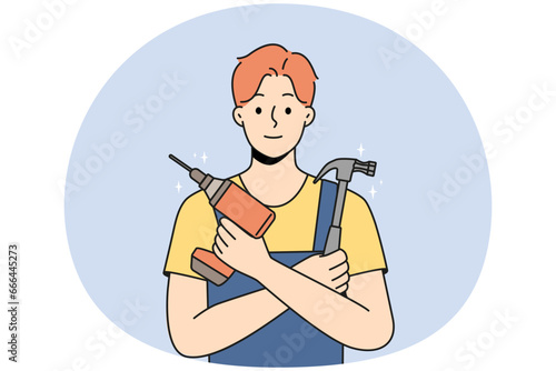 Smiling young male mechanic in uniform holding repairing tools in hands. Happy repairman or engineer with drill and hammer ready for fix. Vector illustration.