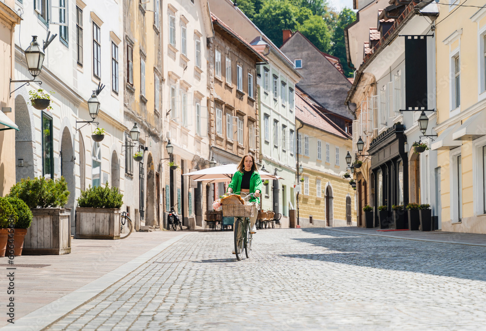 Woman riding bicycle on street in city Woman riding bicycle on street in city