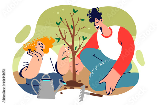 Dad and daughter plant tree in park together to take care of nature or help fight CO2 emissions