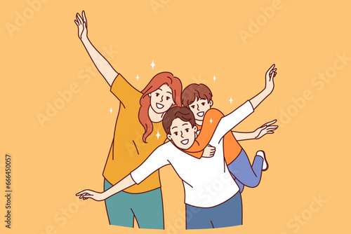 Happy family of mom, dad and child put arms to sides, pretending to be airplanes, and posing for group portrait. Cheerful family having fun and smiling looking at camera to share good mood