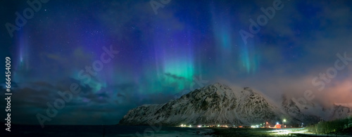 Illuminated nature: sky, stars, aurora, mountains, reflection.