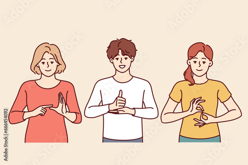 Deaf and mute people use sign language by showing palm signs to communicate instead of speaking. Man and two women make hand gestures teaching sign language interpretation for concept of inclusion