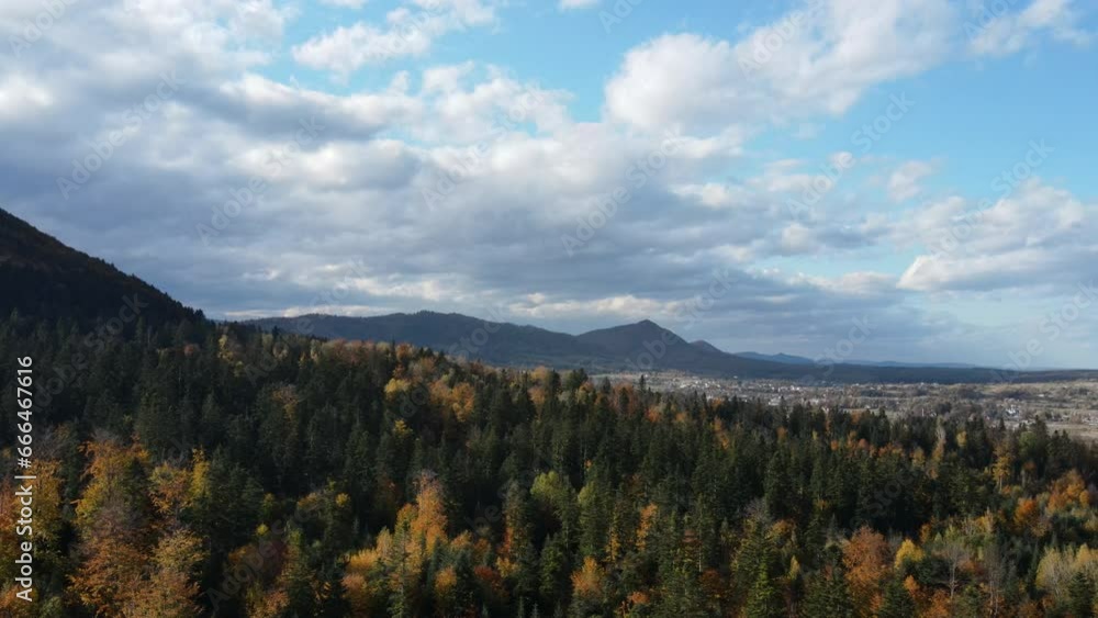 Aerial view of beautiful autumn forest, cloudy sky and amazing mountains at sunny day. Traveling concept of clean pure scenery scene, air camera shot treeline and treetop. Wanderlust destination Aerial view of beautiful autumn forest, cloudy sky and amazing mountains at sunny day. Traveling concept of clean pure scenery scene, air camera shot treeline and treetop. Wanderlust destination