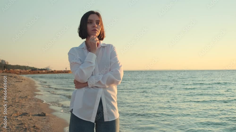 Portrait of beautiful young woman near the sea. Pretty girl looking at seascape and enjoying sunrise on beach. Happy female tourist Portrait of beautiful young woman near the sea. Pretty girl looking at seascape and enjoying sunrise on beach. Happy female tourist