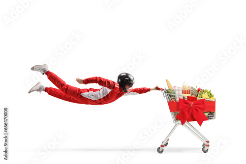 Car racer flying and holding a shopping cart with food and red ribbon bow © Ljupco Smokovski