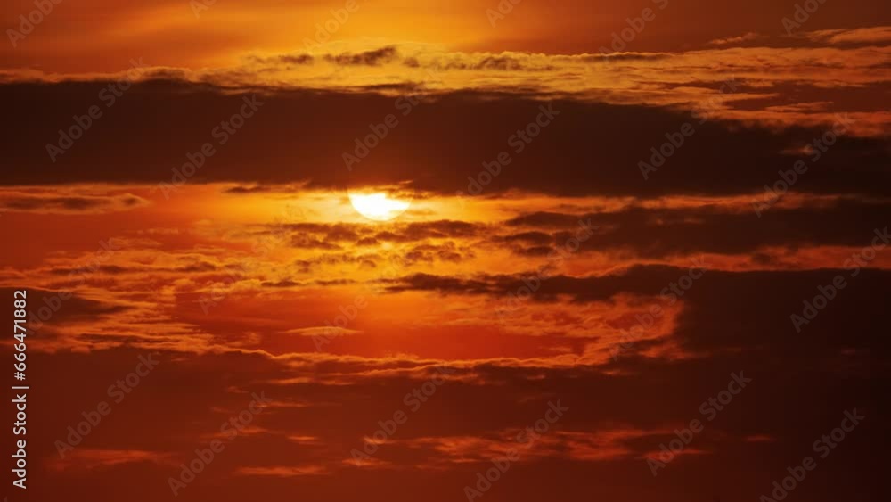 Sunset sun moving behind dark clouds in orange sky. Timelapse, 4K Sunset sun moving behind dark clouds in orange sky. Timelapse, 4K