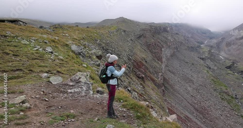 Woman alone hiking on trek path in Cacasus mountains towards Gergeti glaciar Stepantsminda photo