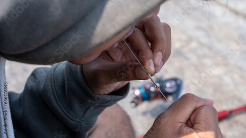 Tableau sur toile an angler tying a fishing line into nylon thread