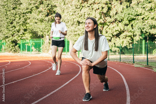 A young woman runner in start position on running track while work out.