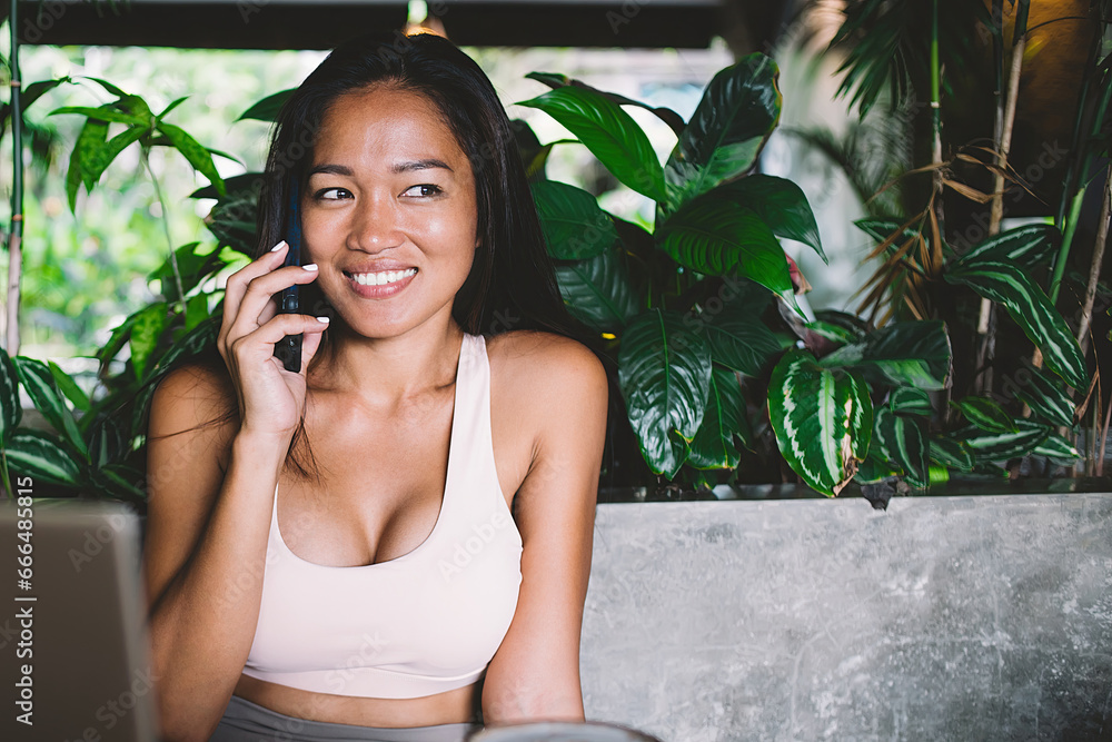 Beautiful young woman calling friend using mobile in cafe Beautiful young woman calling friend using mobile in cafe