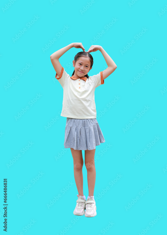 Portrait of Asian girl kid doing heart shape on her head with smiling and look at camera isolated on cyan background. Image full length with Clipping path.