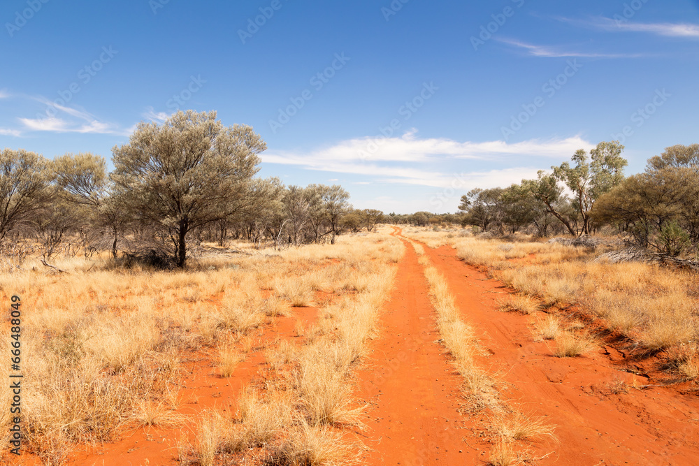 A red dirt track disappearing off into the distance in semi arid outback country in Currawinya National Park in Queensland, Australia. A red dirt track disappearing off into the distance in semi arid outback country in Currawinya National Park in Queensland, Australia.