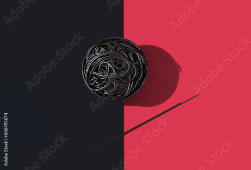 Cuttlefish spaghetti in bowl on red and black surface photo