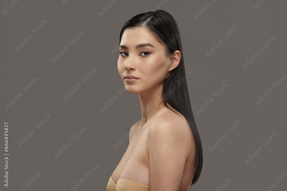 Asian female model with long dark hair looks to camera. Asian female model with long dark hair looks to camera.