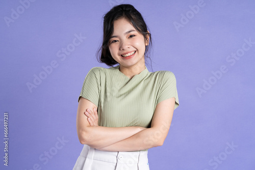 Portrait of beautiful Asian girl posing on purple background © 1112000