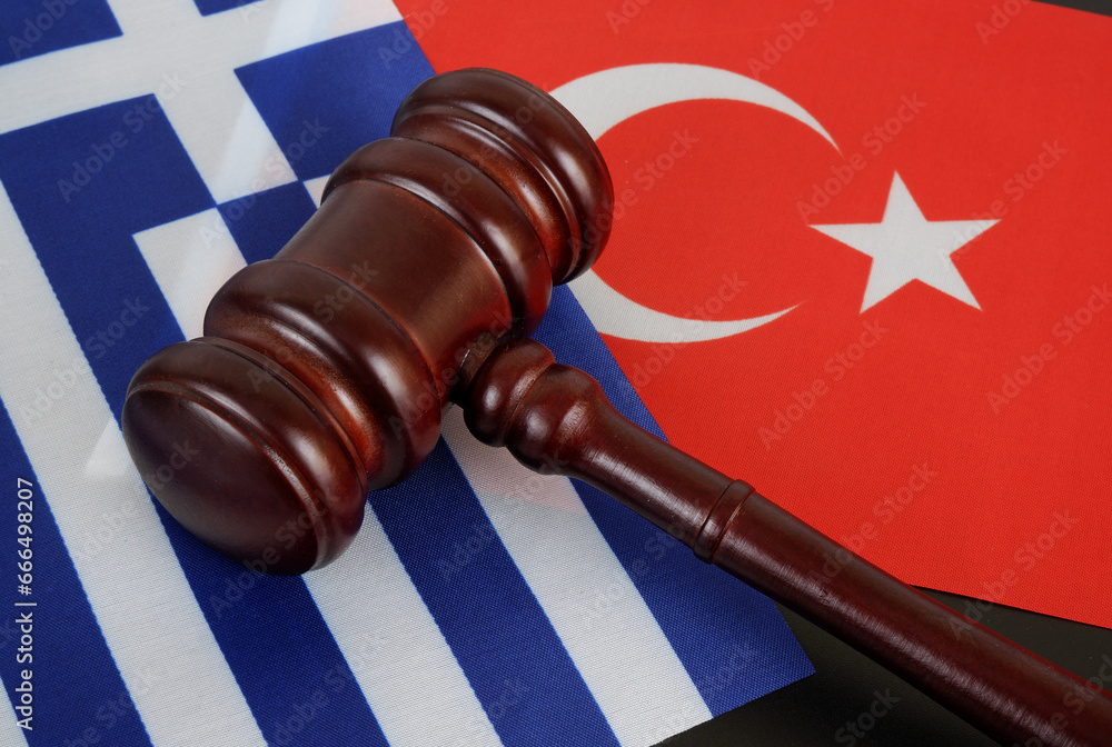 Conflict between Greece and Turkey concept. Gavel on flags of Turkey and Greece close up.