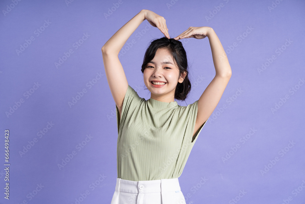 Portrait of beautiful Asian girl posing on purple background Portrait of beautiful Asian girl posing on purple background