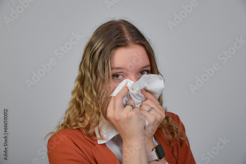 frau grippe schnupfen mit taschentuch schnaupen schnaubt nase nase putzen rotznase krank grippewelle erkältung gesundheit portrait
