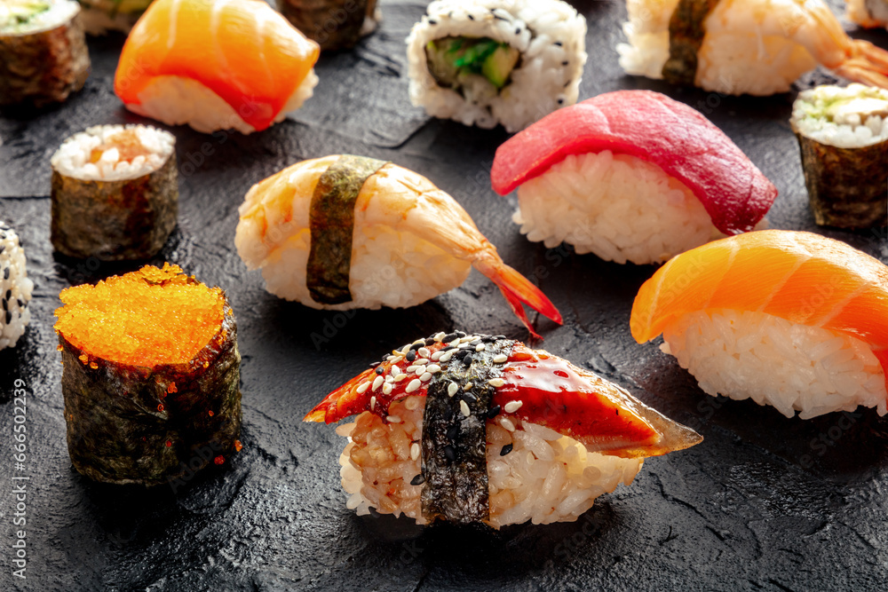 Sushi. An assortment of rolls, maki, nigiri etc on a black background. Japanese restaurant Sushi. An assortment of rolls, maki, nigiri etc on a black background. Japanese restaurant