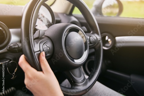 Young girl holding a steering wheel. A girl drives a car. 