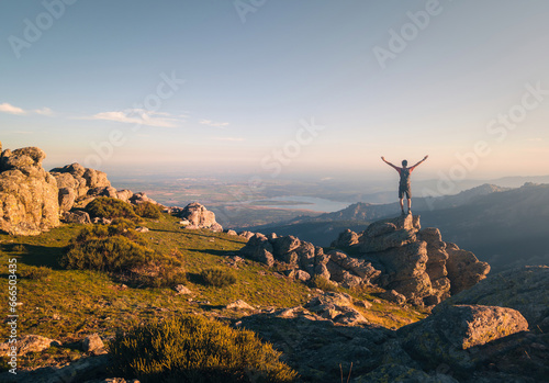 Anonymous climber admiring view from mountain top photo