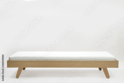 Studio shot of wooden single bed with mattress on white background