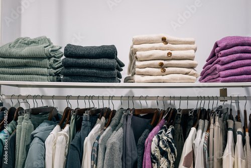 Color coordinated apparel displayed neatly in clothing store.