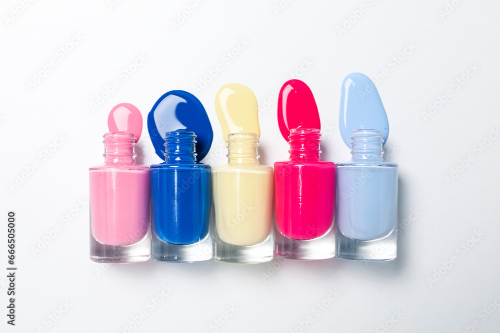 Multicolored open nail polishes on a white background Multicolored open nail polishes on a white background
