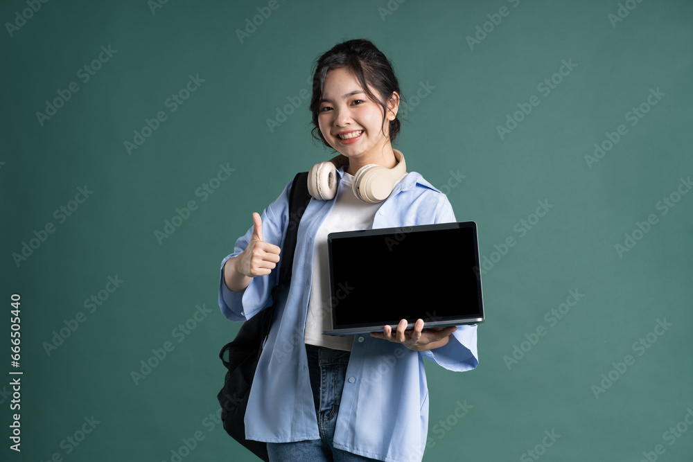 Portrait of a beautiful Asian student on a green background Portrait of a beautiful Asian student on a green background