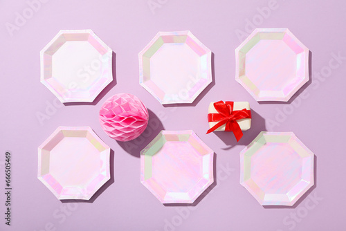 Gift box  plates and paper ball on purple background  top view