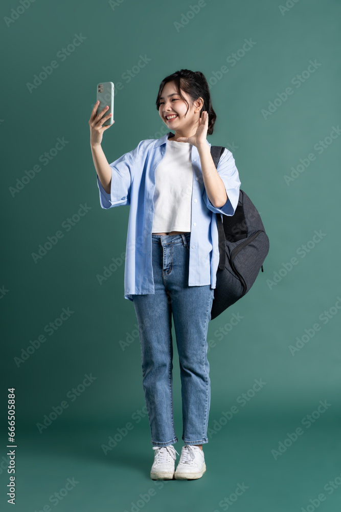 Portrait of a beautiful Asian student on a green background Portrait of a beautiful Asian student on a green background
