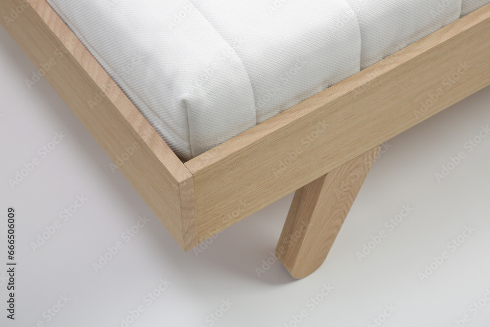 Studio shot of wooden single bed with mattress on white background Studio shot of wooden single bed with mattress on white background