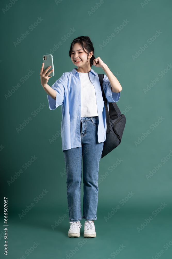 Portrait of a beautiful Asian student on a green background Portrait of a beautiful Asian student on a green background