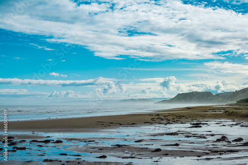 Mist rising over water at Makorori Beach obscuring distant mountains. Gisborne, New Zealand