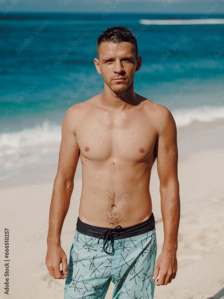 Portrait of attractive young man on a sandy beach. Caucasian man looking at camera Portrait of attractive young man on a sandy beach. Caucasian man looking at camera