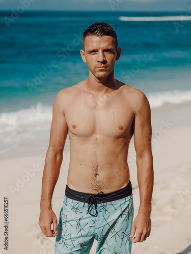Portrait of attractive young man on a sandy beach. Caucasian man looking at camera