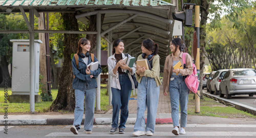 Obraz premium Happy young student chat with each other after class. Guy and girls wear casual clothes to study. Lifestyle concept, sincere emotions