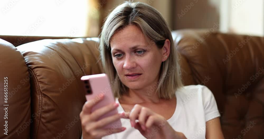 Woman on sofa reading from smartphone screen, close-up. The concept of behavioral addiction, rest with the phone Woman on sofa reading from smartphone screen, close-up. The concept of behavioral addiction, rest with the phone