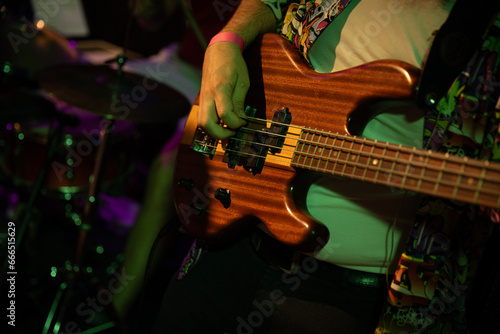 Bass guitar player or guitarist playing music instrument (focus on hand)