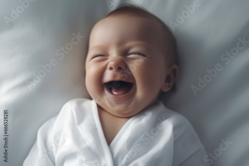 Laughing infant girl wrapped in white photo