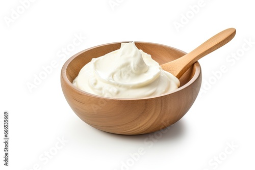 Wooden bowl and spoon containing sour cream mayonnaise and yogurt isolated on a white background with a full depth of field No words are used directly from