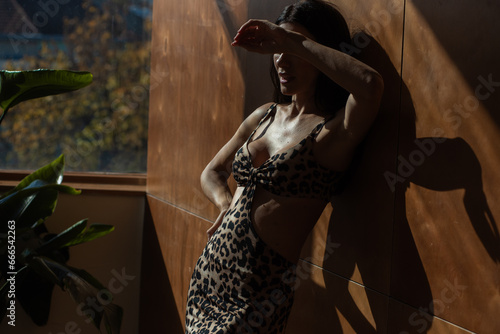 Woman in leopard print summer dress, tropical resort